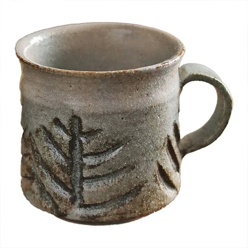 Handmade ceramic coffee mug with rustic leaf design, vintage style drinkware.