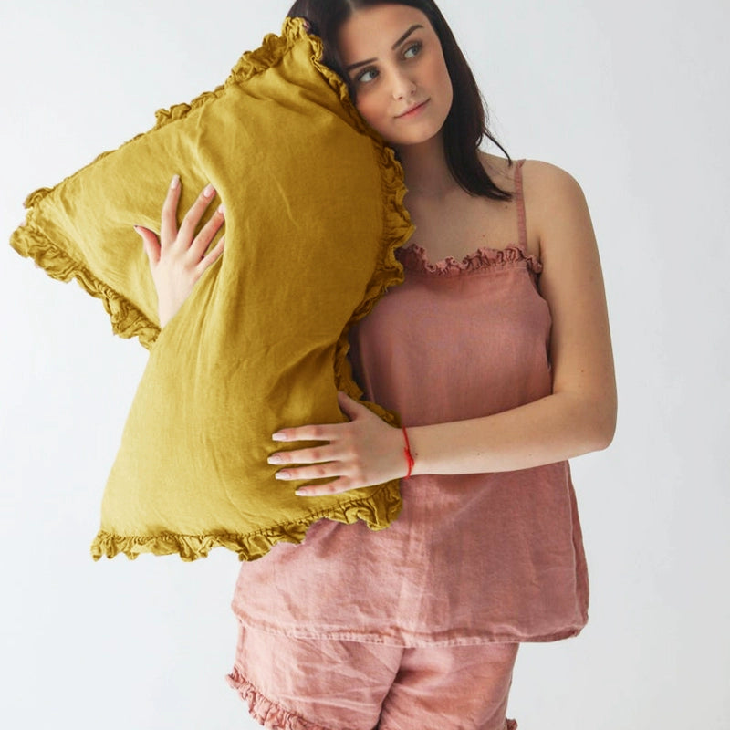 Mustard yellow Rustic Linen Pillowcases with Frills, set of 2, held by a woman in pink linen.