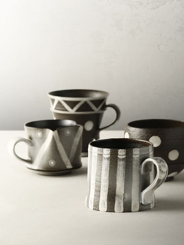 Earthy brown and gray handmade ceramic mugs with geometric stripes and dots patterns in matte rustic stoneware.