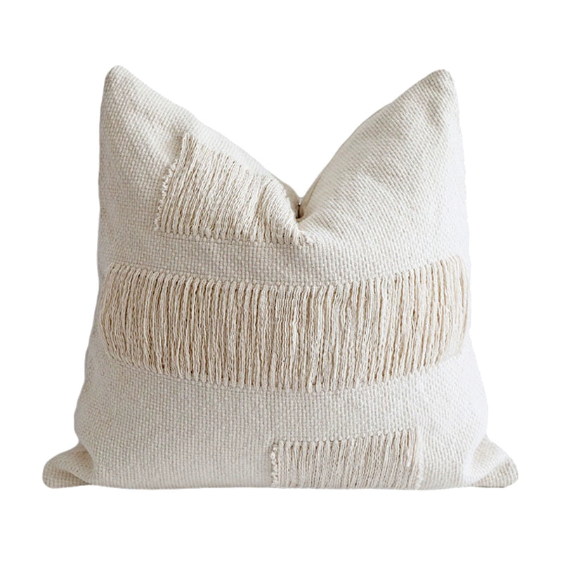 Cream woven throw pillow with fringe detailing, perfect for modern boho decor.