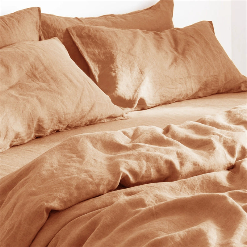 Soft natural linen bedding set in terracotta, featuring cozy pillows and a rumpled duvet.