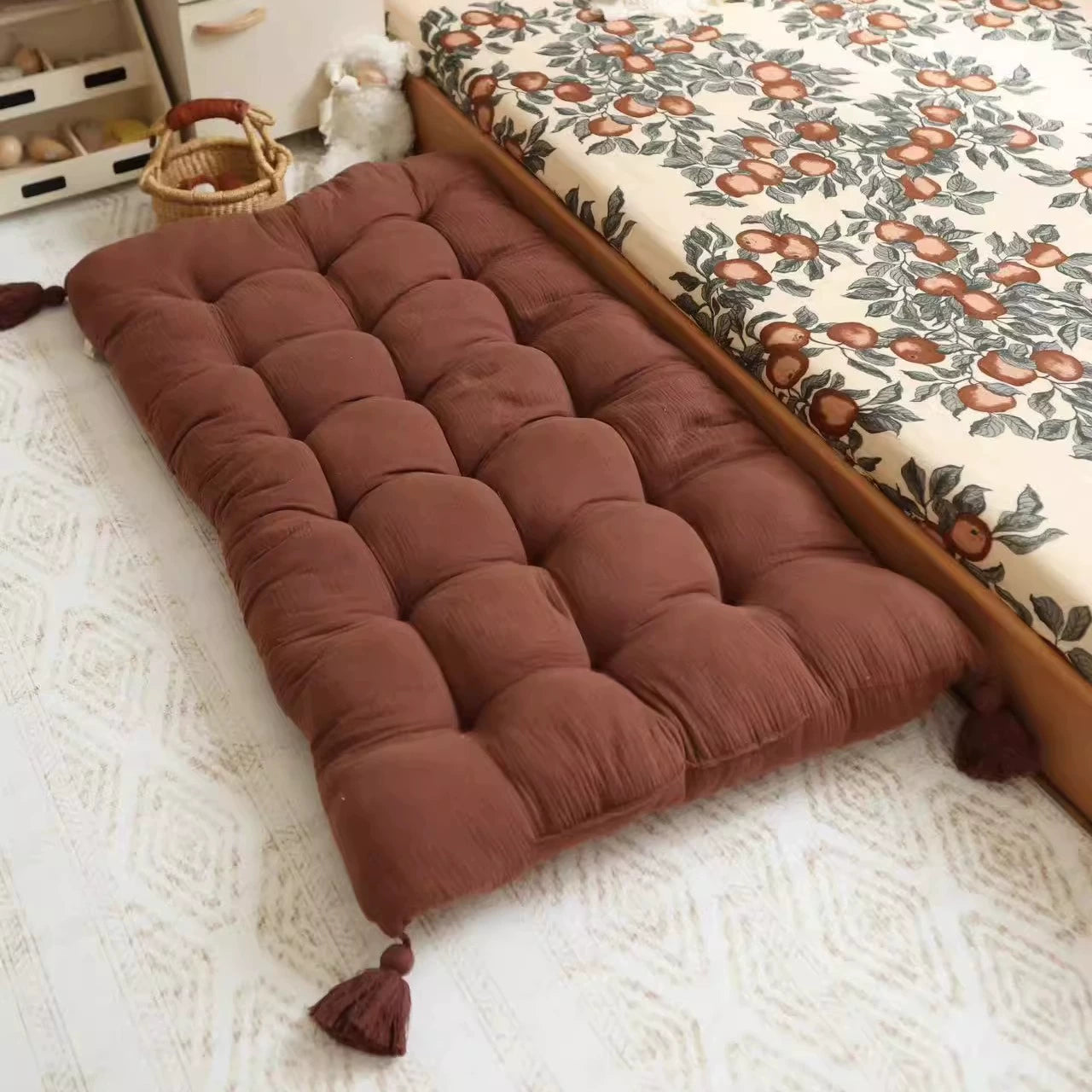 Brown tufted floor cushion with tassels, kids' room play mat.