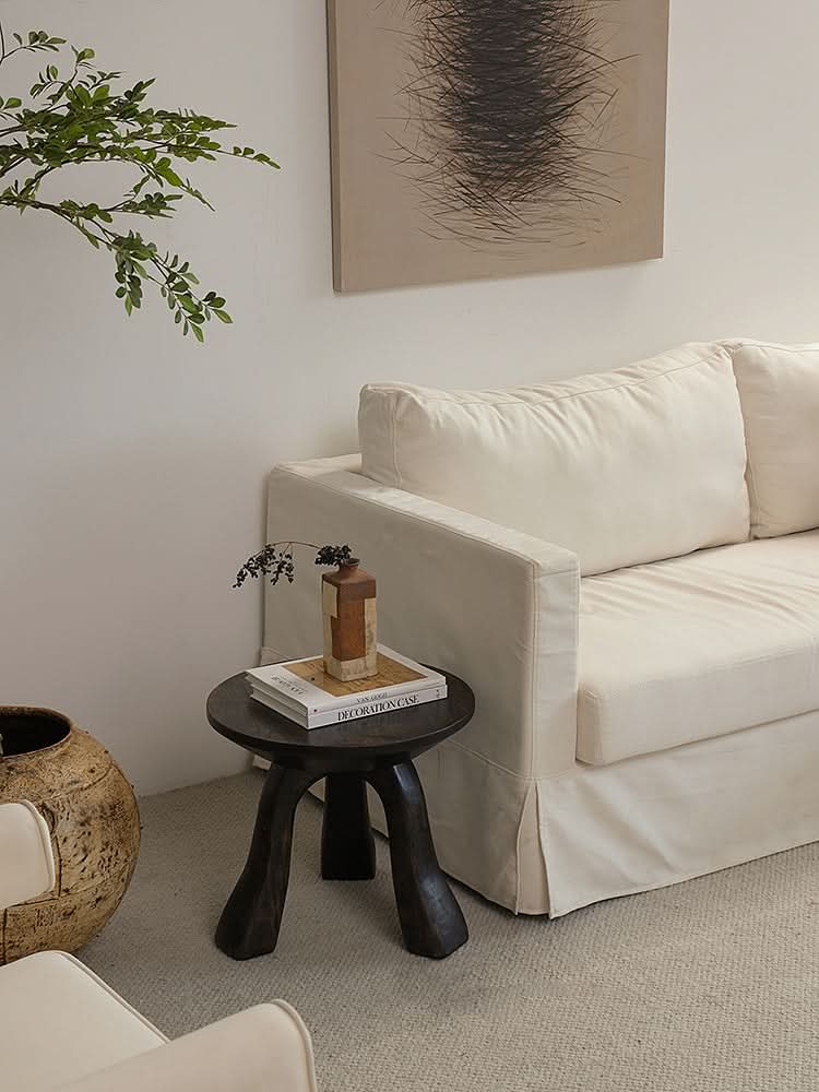 Rustic Wooden Side Table with books and vase on it, next to a cream sofa.