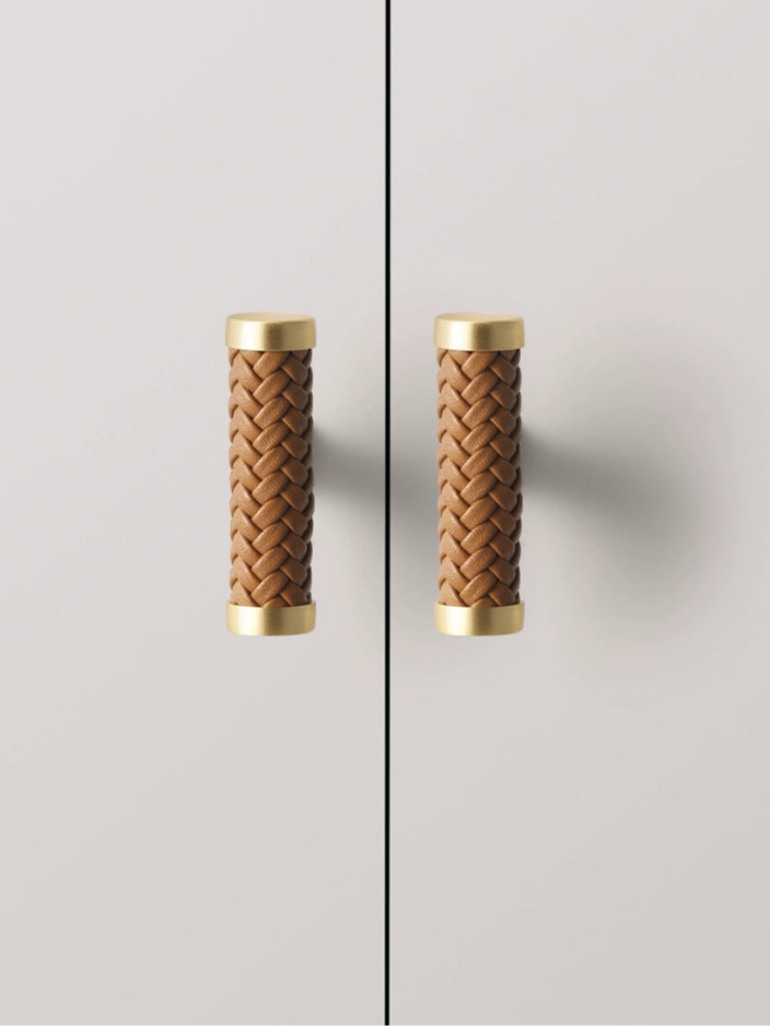 Woven leather drawer pulls with gold finish on white cabinets