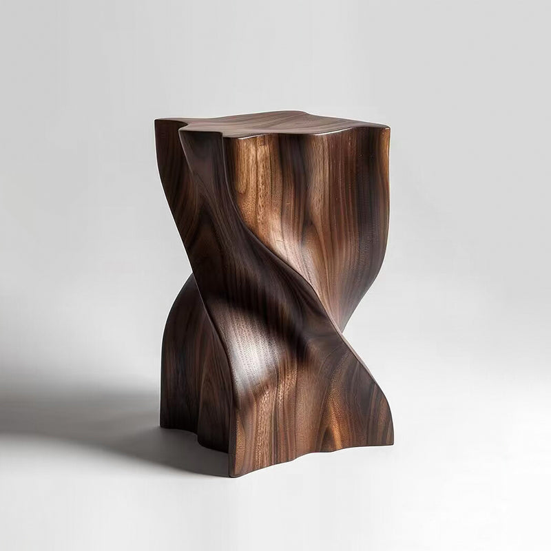 Sculptural walnut wood stool with modern twisted design on a white background.