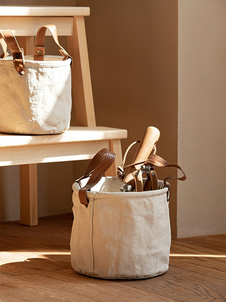 Set of 3 cream-colored canvas plant pots with brown leather handles.  Rustic style.