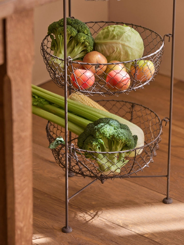 Rustic 3-tier wire fruit basket stand.  Dark metal wire baskets hold produce like broccoli, apples, and cabbage.  Kitchen organizer.