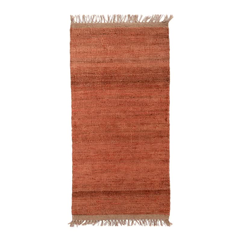 Handwoven Jute Rug in rust tones with fringed edges. Natural, rustic home decor.