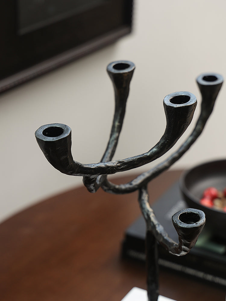 Modern Black Metal & Marble Candle Holder with branching arms on a wooden table.
