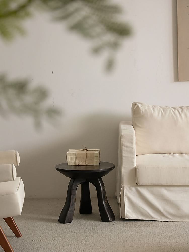 Rustic wooden side table with books in a neutral living room setting