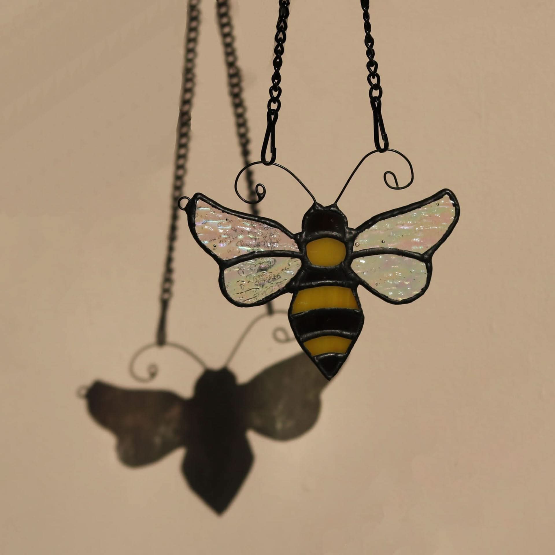 Stained Glass Bumblebee Suncatcher with iridescent wings and yellow/black body, casting a shadow.
