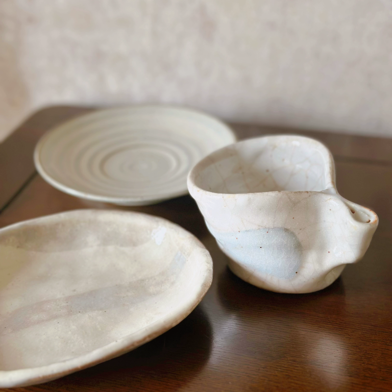 Hand-thrown Japanese vintage teacup and saucer set, textured ceramic, cream and blue tones.