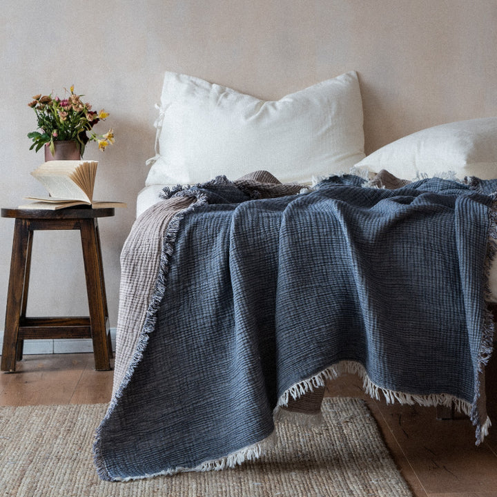 Pink and beige textured throw blanket on bed.