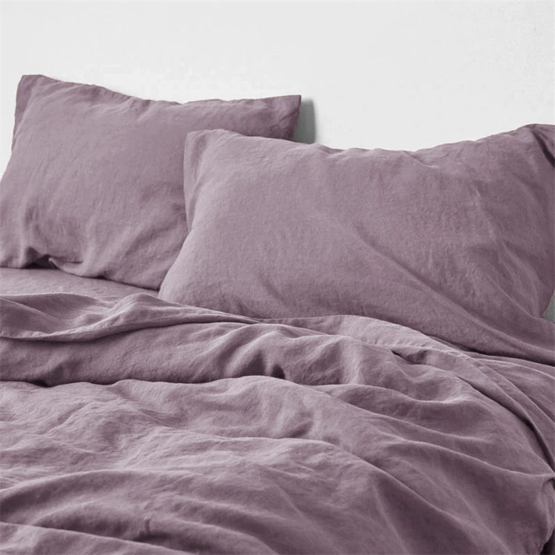 Soft lavender natural linen bedding set with two pillows on a bed.