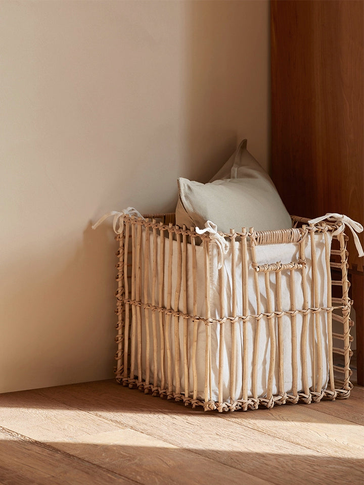 Square woven rattan storage basket with linen lining. Light beige color.  Natural material.  Home decor.