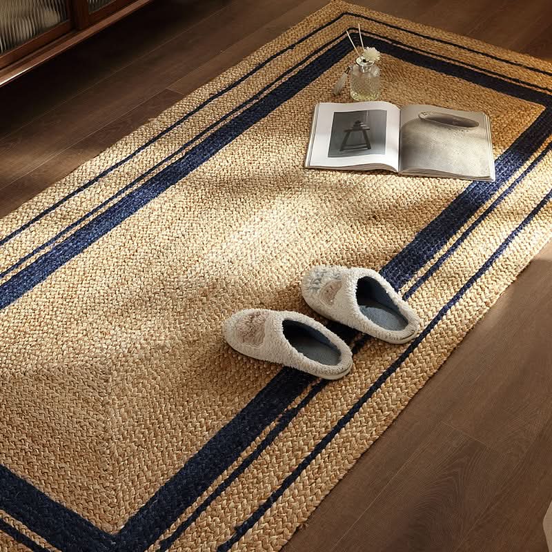 Natural jute rug with navy stripes and cozy slippers on wood floor.