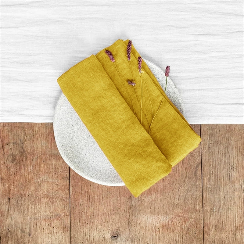 Yellow linen table napkins knotted on a plate, set of 4. Home decor.
