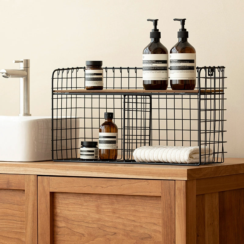 Black metal wire wall shelf with wooden top, holding toiletries and a towel, double tiered kitchen storage organizer.