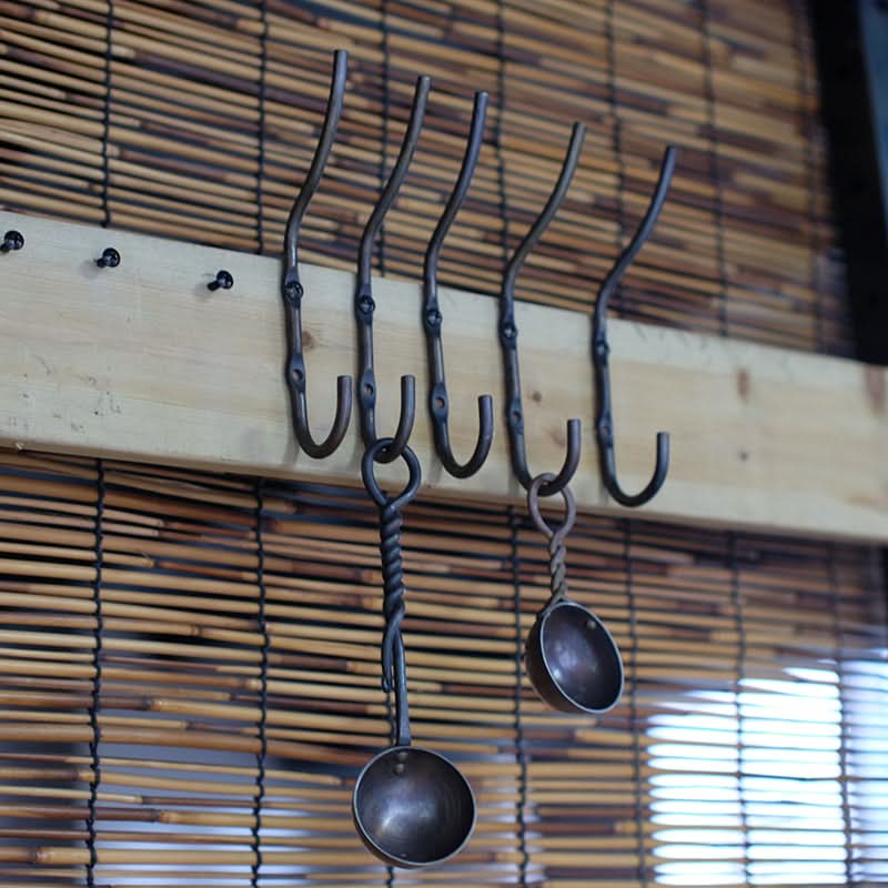 Rustic Wall Hooks - Hand Forged Iron Hooks on wood plank with bamboo backdrop.