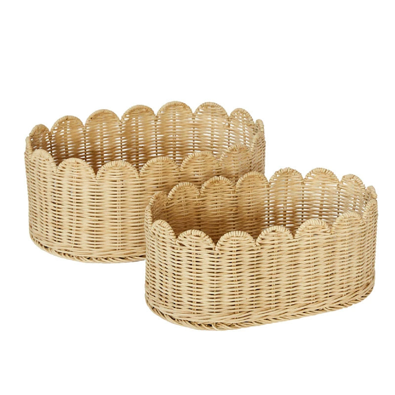 Two light beige rattan storage baskets with scalloped edges.  Oval shape, woven design.