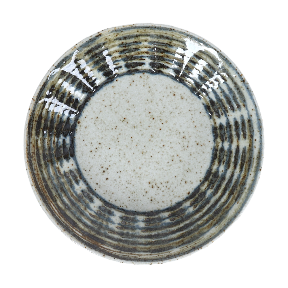Overhead view of a round ceramic plate featuring a dense, swirling dark brown pattern radiating from the speckled center.