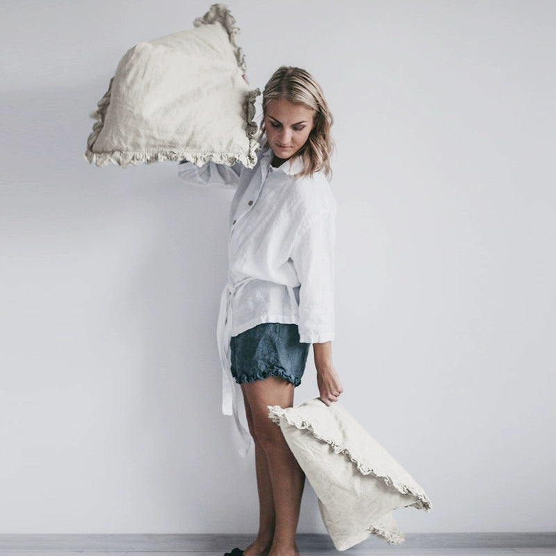 Rustic linen pillowcases with frills, set of 2, cream colored, displayed by a model.