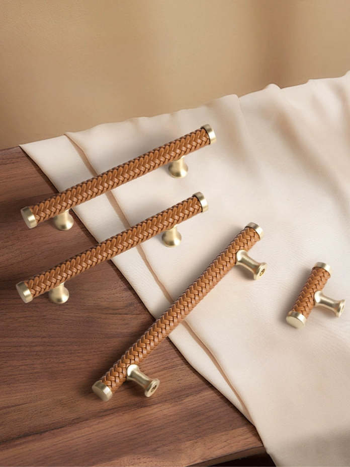 Woven leather drawer pulls in a light brown color with a gold metal base.  Modern handles for cabinets and dressers.