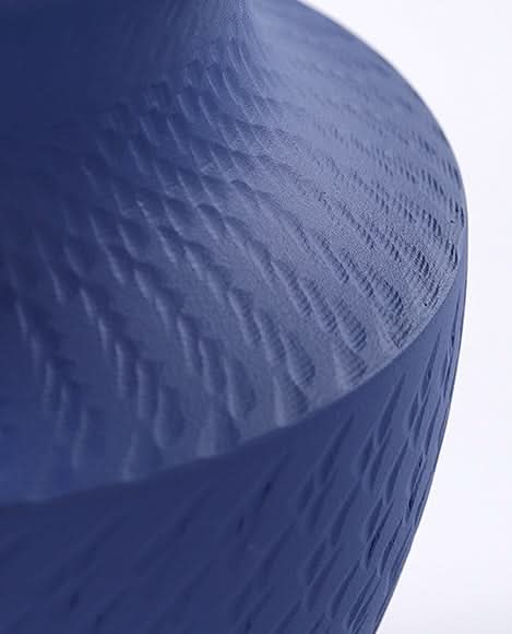 Vibrant blue textured vase with unique surface pattern. Home decor accent.
