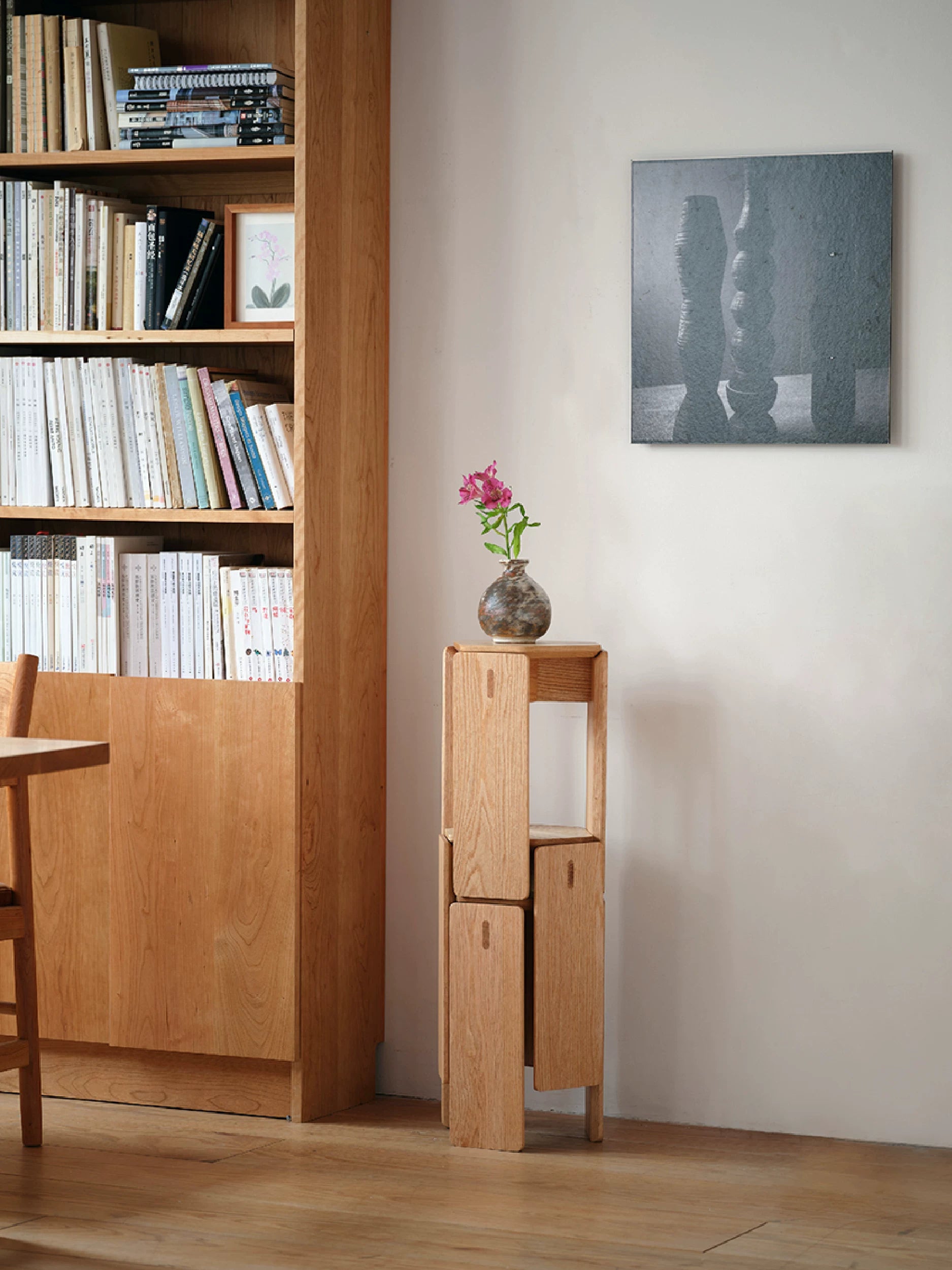 A minimalist solid wood stool with a geometric design and natural grain finish.