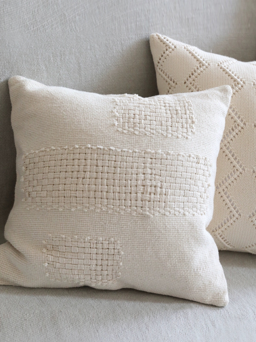 Stylish woven throw pillows in natural tones with modern boho texture on a gray sofa.