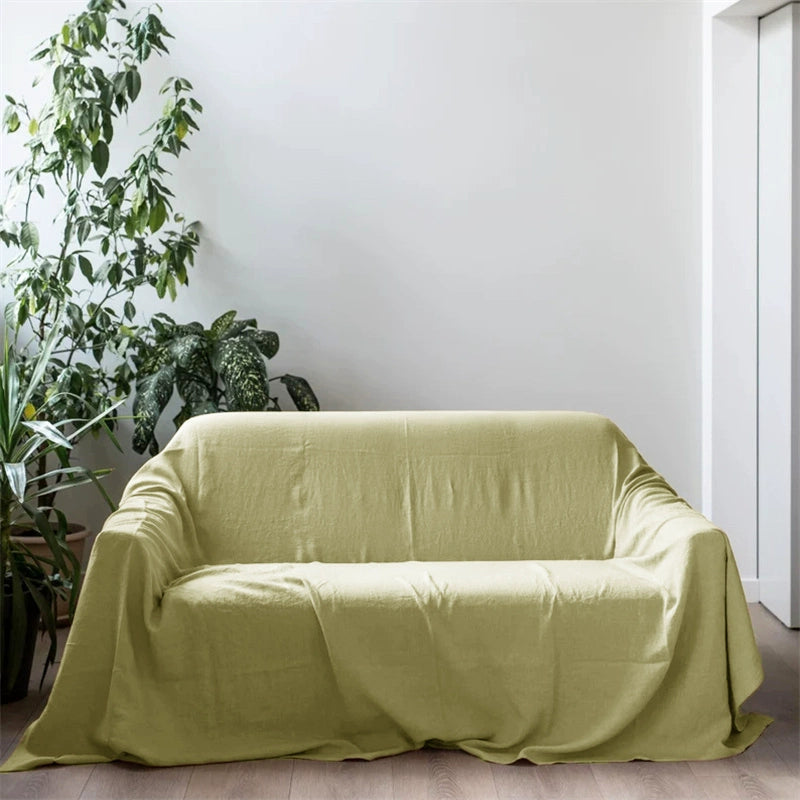 Mustard yellow linen sofa throw blanket draped on a sofa, with plants.