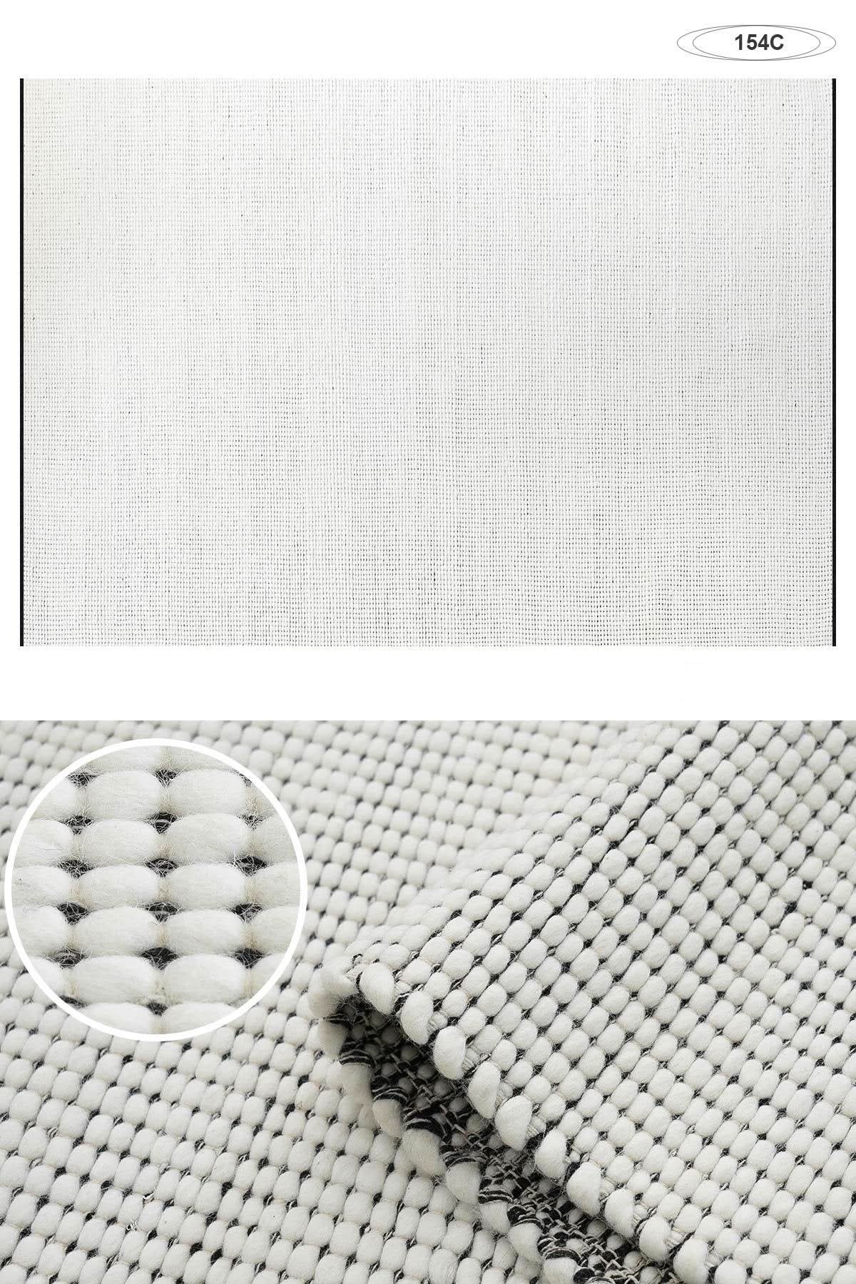 Close-up of a wool handwoven cream rug showing thick texture and intricate weaving. Home decor.