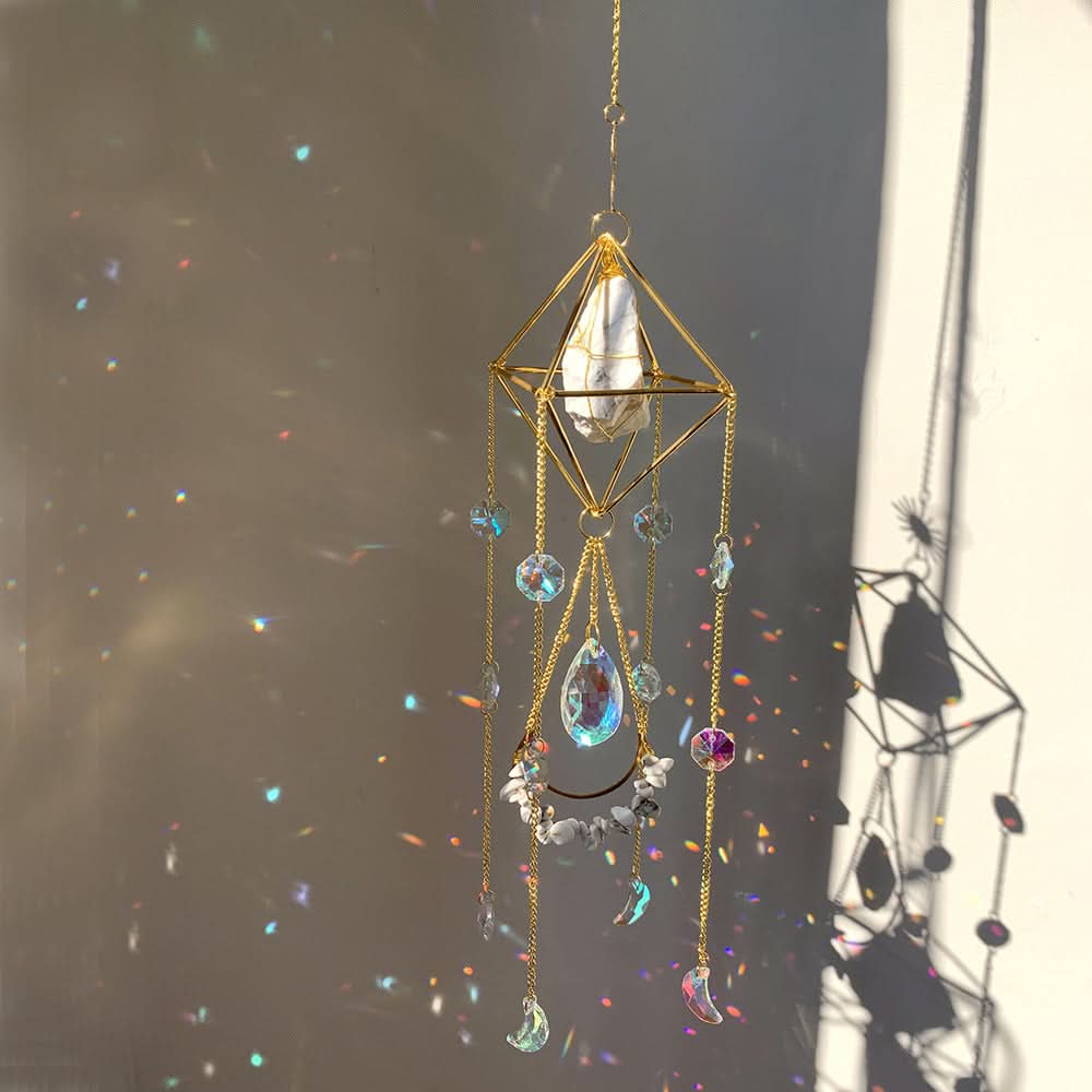 Gold geometric crystal diamond sun catcher with prismatic light reflections.