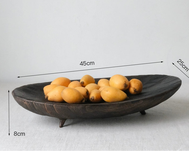 Dark brown wooden oval platter with legs, filled with yellow fruits.  Dimensions 45cm x 25cm x 8cm.