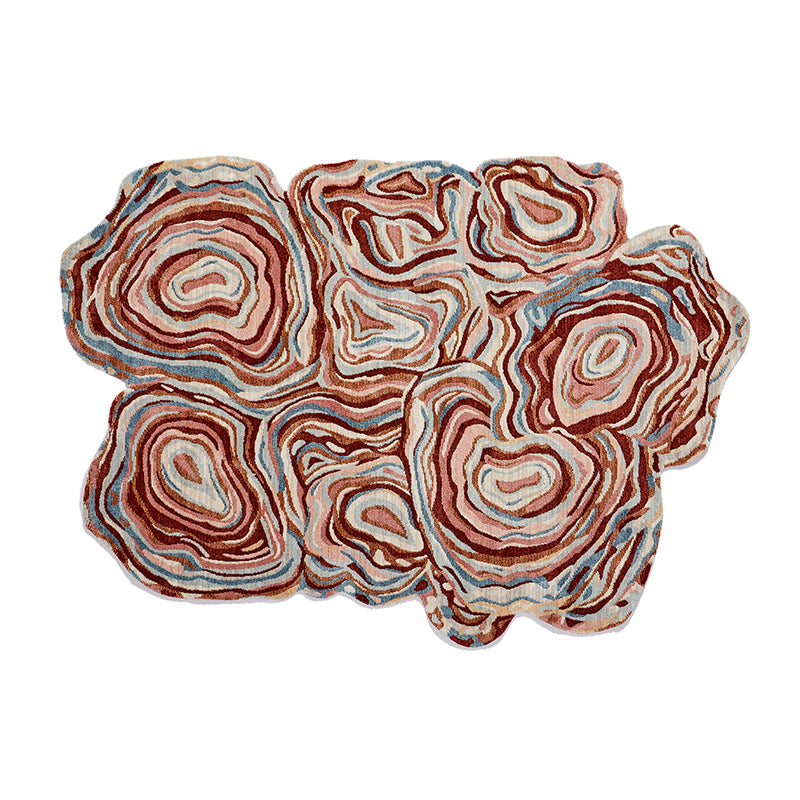 Unique abstract rug with red, pink, blue, and brown agate-like patterns for fall/winter living room accent.