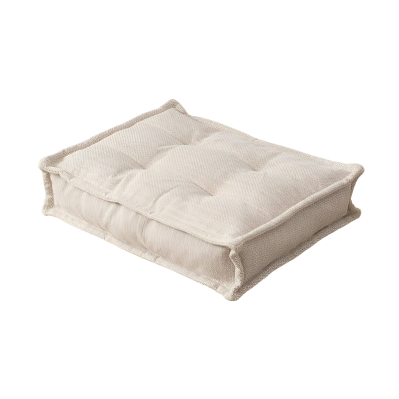 Beige rectangular cushion, tufted design,  fabric upholstery.