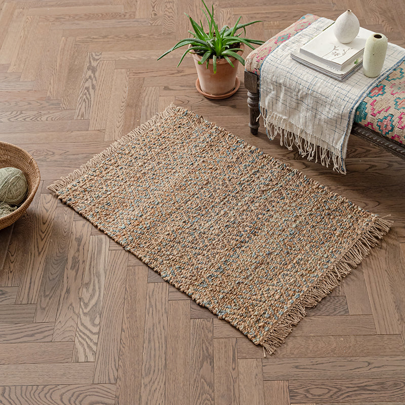 Beige and blue woven rug with fringe.