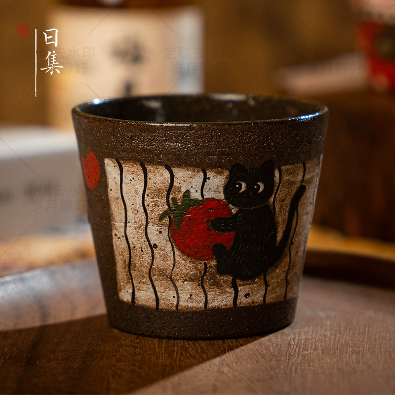 Traditional Japanese hand-painted ceramic cup with black cat and strawberry design. Decorative tea cup.