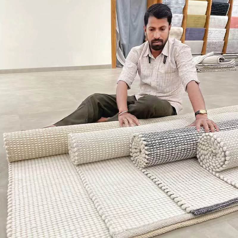 Wool Handwoven Cream Rug laid out with a weaver in a home decor setting.