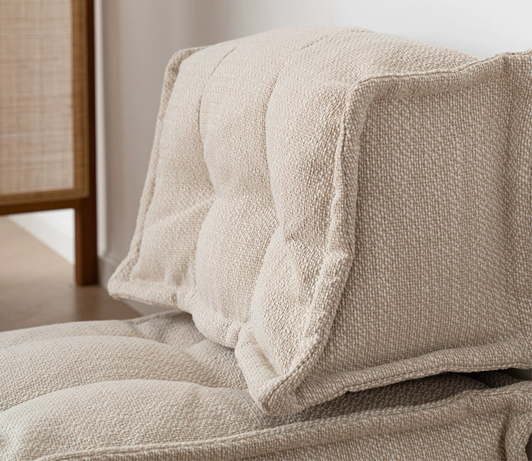 Modern beige fabric modular sofa detail, showing tufted cushions and textured upholstery.