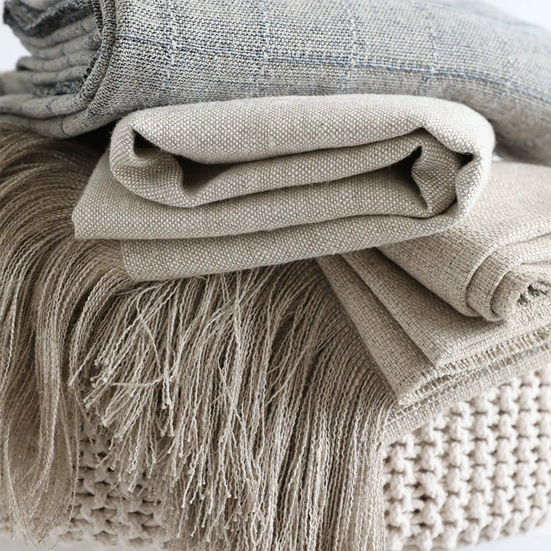 Natural beige linen table runner with fringes, textured fabric detail.