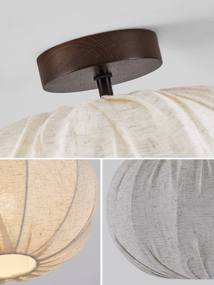 Beige linen pleated round ceiling lamp with dark wood base. Modern design, warm light.
