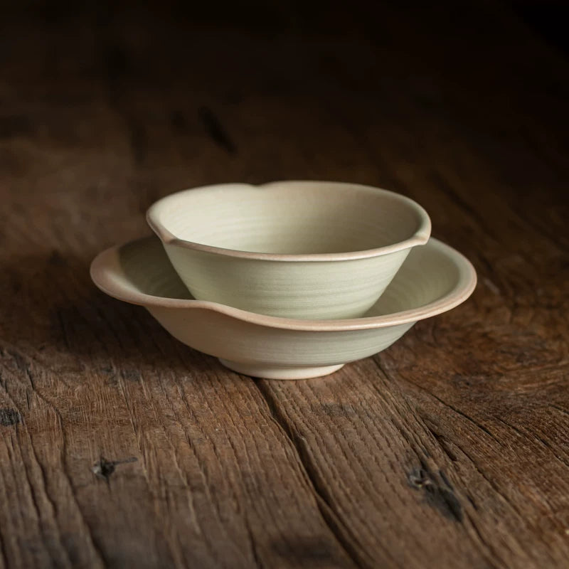 Stack of two light ceramic bowls with irregular rims, featuring a soft, pale green hue.