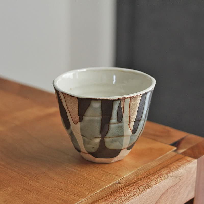 Hand-Painted Tea Cup in Autumn & Winter hues, ceramic, on a wooden surface.