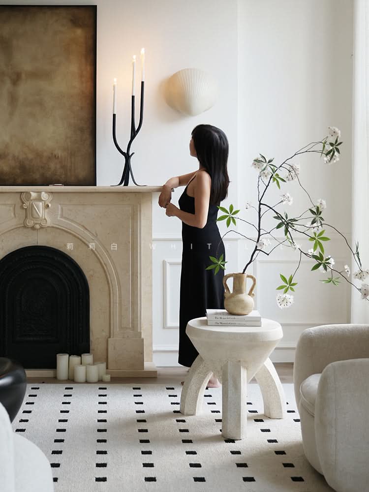 Modern Branch Candle Holder: black metal candelabra with white candles on a marble mantel.