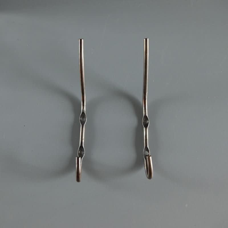 Two industrial style wall hooks, brushed metal finish, on a gray background.