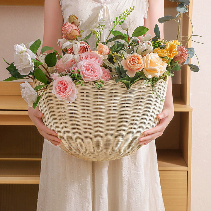 Beige scalloped wicker wall basket filled with flowers.  Natural weave, decorative planter.
