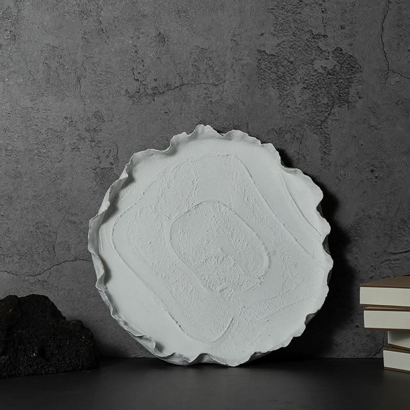 Wabi-sabi ceramic serving dish with textured surface on dark background.