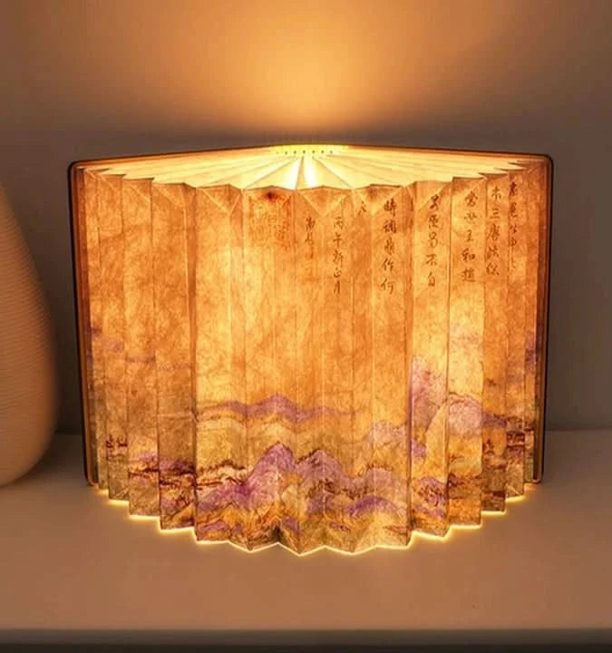 Warm, glowing customizable book paper table lamp with mountain design and Chinese calligraphy.