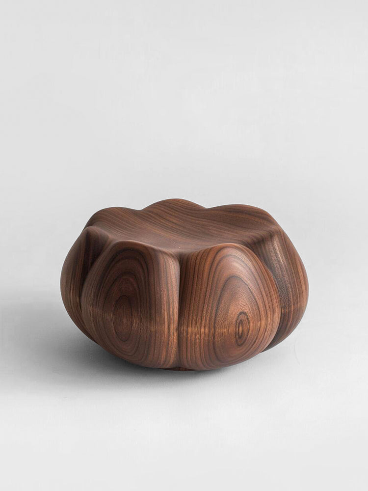 Hand-carved walnut wood pumpkin stool with rich grain detail, on a light grey background.
